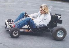 a woman is riding an electric go - kart