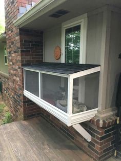 an open window on the side of a house with a dog laying in it's bed