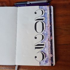 an open notebook with the word omen written in black ink on top of it