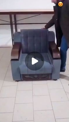 a man is pushing a chair in the middle of a room with tile flooring