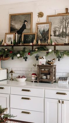 a kitchen decorated for christmas with pictures on the wall and other holiday decorating items