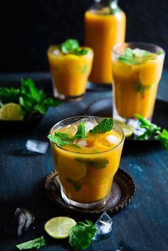 two glasses filled with orange juice and garnished with mint