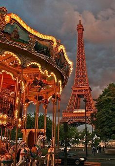 the eiffel tower is lit up in pink and gold for this carousel ride