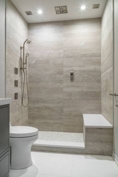 a white toilet sitting next to a walk in shower