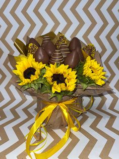 a bouquet of sunflowers and chocolate covered strawberries on a chevron background