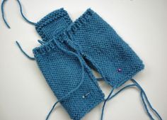 two blue knitted mittens sitting next to each other