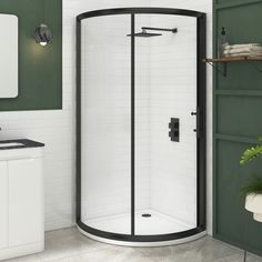 a bathroom with green walls and white tiles on the floor, including a corner shower stall