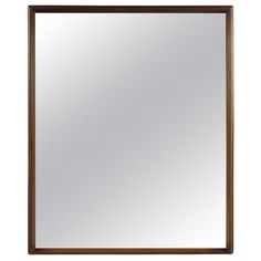 a wooden framed mirror with a brown frame and wood trim on the bottom, against a white background