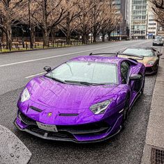 three purple sports cars parked on the side of the road