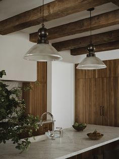 two lights hanging over a kitchen counter top