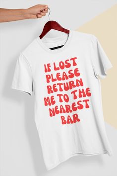 Get ready to make a statement with this hilarious "If Lost, Return Me to the Nearest Bar" t-shirt. Perfect for any party animal, this shirt is the perfect accessory for a night out with friends or a casual day out. Made from soft, comfortable cotton, this shirt will keep you looking and feeling great all day long. Whether you're a beer lover, wine enthusiast, or just love a good cocktail, this shirt is the perfect way to show off your love for a good time. With its unique design and clever messa Drinking Tshirt Ideas, Bar Tshirt Ideas, White Band Merch Top With Funny Text, Fun Slogan Crew Neck Top, Funny Red Tops With Letter Print, Red Funny Tops With Letter Print, Band Merch Crew Neck Top With Funny Text, Funny Red Screen Printed Top, Funny Red Top With Screen Print