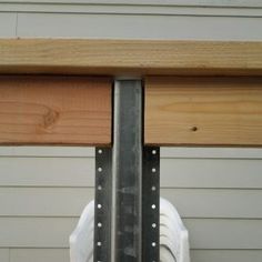 a close up of a wooden beam on the side of a house with metal brackets