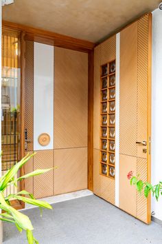 an open door to a room with wooden paneling on the wall and plant in front