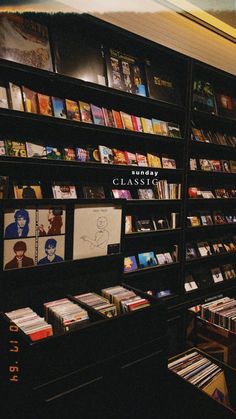 a book store filled with lots of books on shelves next to a wall full of cds