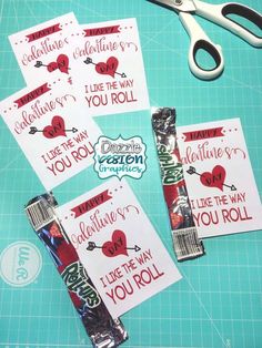 valentine's day candy wrappers and scissors on a cutting board with stickers that say i love the way you roll