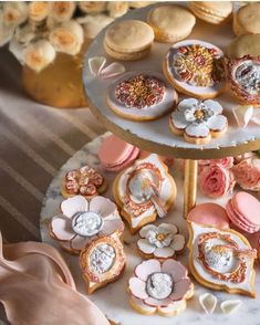 two tiered trays filled with cookies and pastries on top of a table