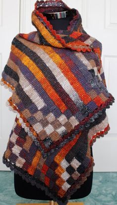 a multicolored shawl on a mannequin with a white door in the background