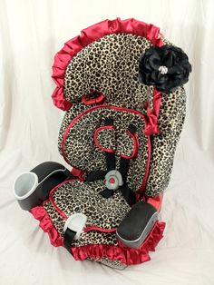 a leopard print car seat cover with red ruffles and black flower on top