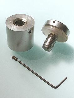 an assortment of metal parts on a white surface with a screw and nut in the middle