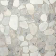 white and grey pebbles are arranged on the wall