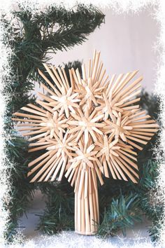 a cross made out of sticks sitting on top of a christmas tree