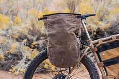 a bicycle with a bag strapped to the front wheel