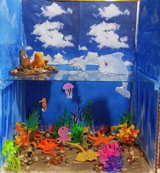 an aquarium filled with different types of sea animals and marine life in blue water under cloudy skies