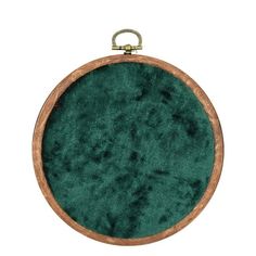 a green round ornament hanging from a wooden frame on a white background with clippings