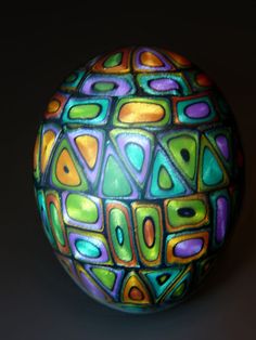 a multicolored glass ball sitting on top of a table next to a black background