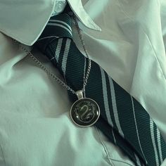 there is a tie with the letter s on it and a pendant attached to it