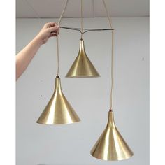 two brass pendant lights hanging from a ceiling