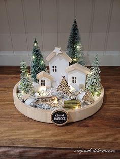 there is a small christmas village with trees and lights on the table in front of it