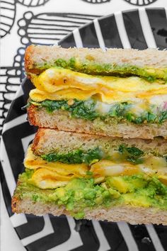 two sandwiches stacked on top of each other with cheese and broccoli in between