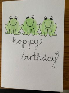 a card that says happy birthday with three green frogs