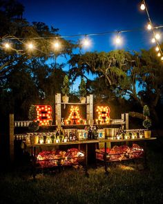 an outdoor bar is lit up with lights and signs that spell out the word bake