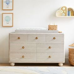 a baby's crib in the corner of a room with pictures on the wall