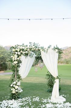 an outdoor wedding setup with white flowers and greenery