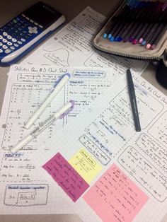 a bunch of paper with some writing on it next to a calculator and pencils