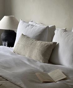 a bed with white linens and two lamps