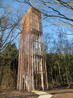 a tall wooden tower sitting in the middle of a forest