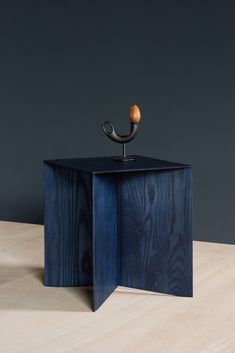 a wooden table with a metal pipe on it's top and an object in the middle