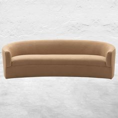 a tan couch sitting in front of a white wall