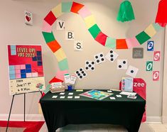 a black table topped with cards and dices next to a sign that says vbs