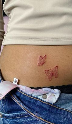 a woman's stomach with two small butterflies on her belly and the bottom part of her stomach