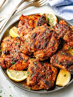 a plate full of chicken with lemon slices and parsley