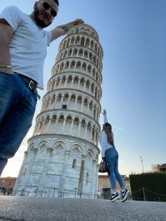 a man and woman standing in front of the leaning tower