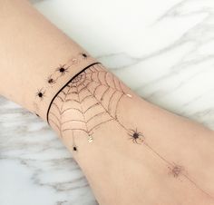 a spider web tattoo on the wrist with stars and sparkles attached to it's arm