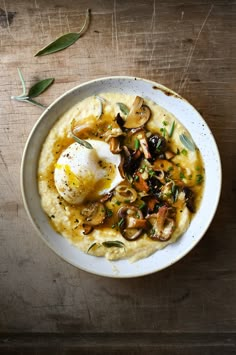 a bowl of grits with an egg on top next to a plate of mashed potatoes