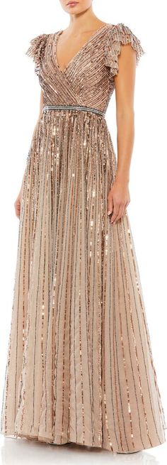 a woman in a long dress with sequins on the shoulders and shoulder, wearing a