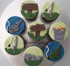 cupcakes decorated with fishing related items on a silver platter that says happy birthday